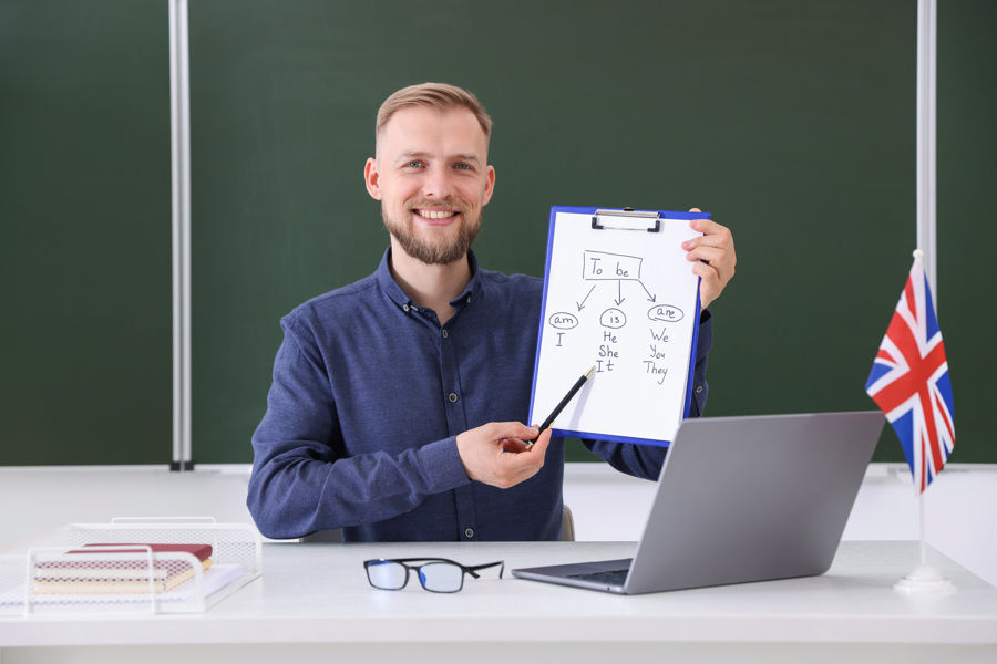 smiling-male-teacher-pointing-at-english-grammar-c-2026-05-19-20-08-27-utc.jpg