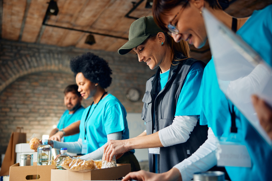 happy-woman-packing-donated-food-with-group-of-vol-2026-03-16-03-30-12-utc.jpg
