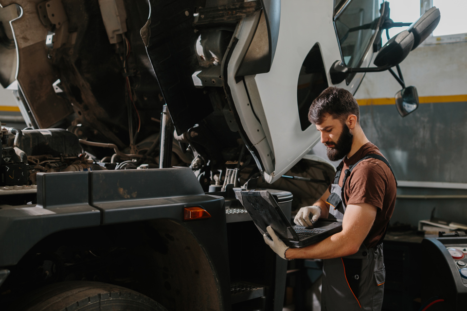 mechanic-using-laptop-diagnosing-truck-engine-prob-2026-03-24-05-15-32-utc.jpg